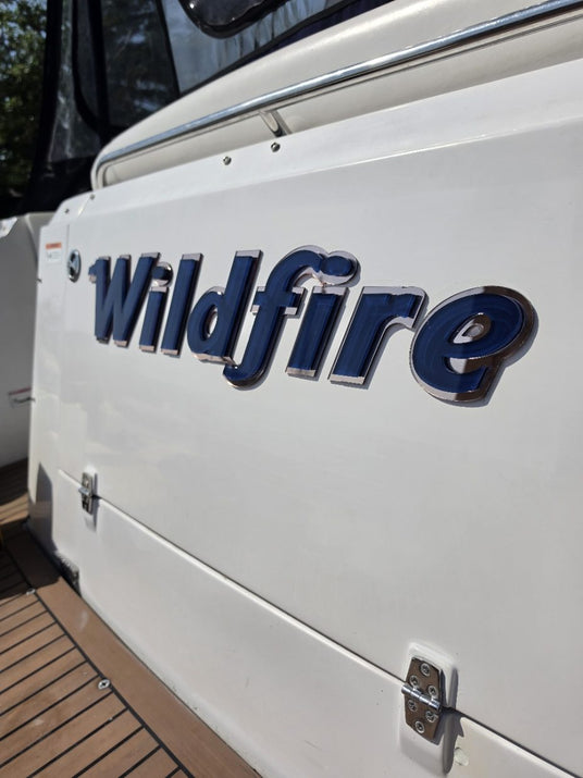 Wildfire lettering close-up: deep blue face with chrome edging