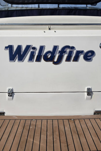 Wildfire boat name across the full transom above the swim platform