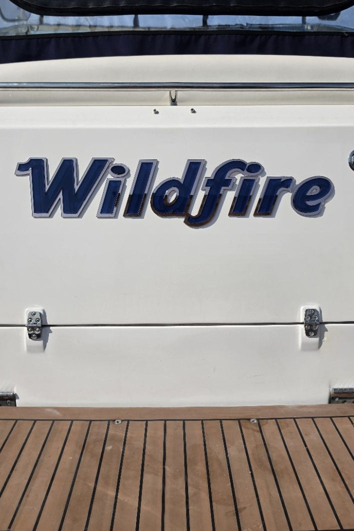Wildfire boat name across the full transom above the swim platform